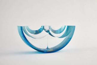 Blue and clear boat shaped sculpture made of glass.