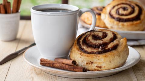 Plate of cinnamon bun and coffee